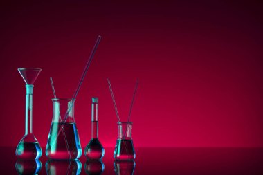 Kimyasal laboratuvar kavramı. Sıvı ile denemeler yapın. Kırmızı arka plan. Logo için yer.