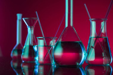 Kimyasal laboratuvar kavramı. Sıvı ile denemeler yapın. Kırmızı arka plan. Logo için yer.