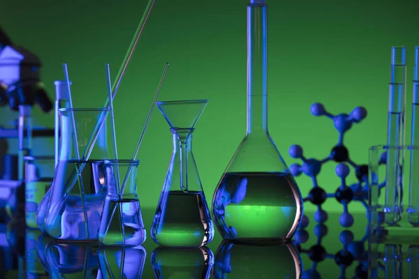 Chemical laboratory concept. Experiment with liquids.  Green background. Place for logo.
