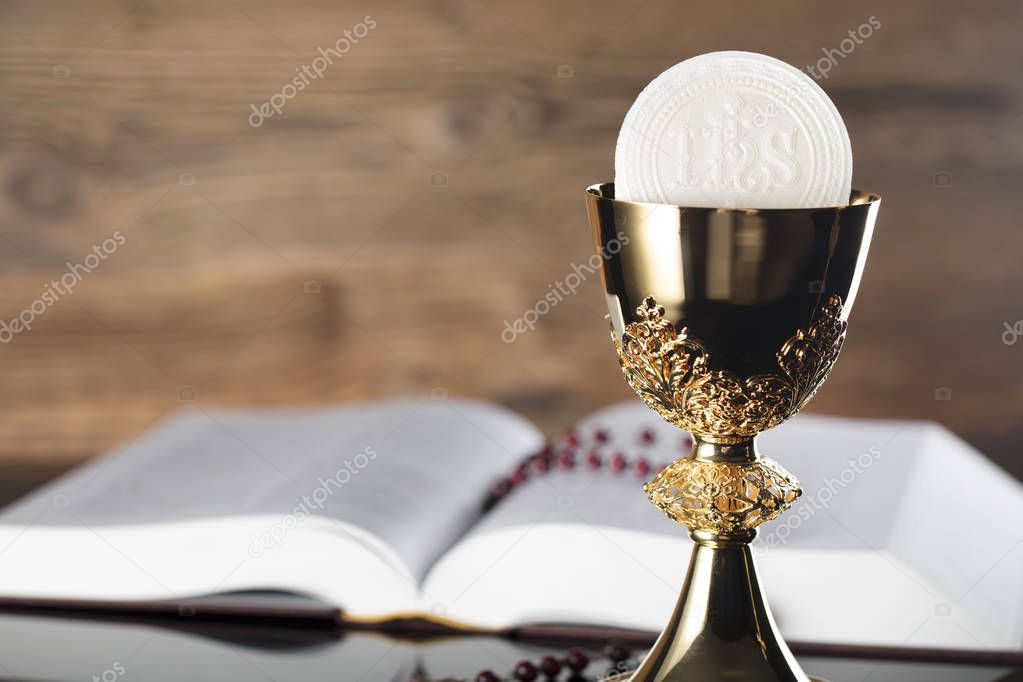 Holy communion concept. Holy Bible, rosary and golden chalice.
