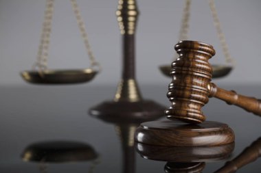 Yargıçlar tokmak ve adalet cam masa ve gri arka plan üzerinde ölçeği. Hukuk ve adalet kavramı.