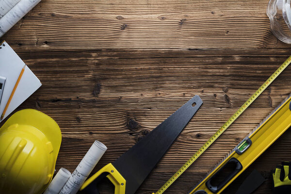 Contractor concept background. Top view. Place for typography. Blueprints and contractor tools and equipment on wooden table.