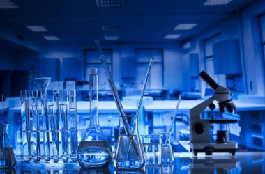 Bilim kavramı. Modern laboratuvar iç. Laboratuar kapkacakları ve mikroskop. Kimyasal deney. Mavi arka plan.