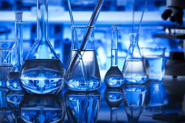 Bilim kavramı. Modern laboratuvar iç. Laboratuar kapkacakları ve mikroskop. Kimyasal deney. Mavi arka plan.