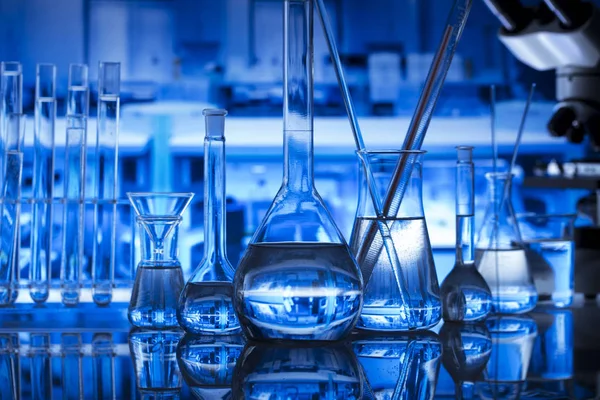 Bilim kavramı. Modern laboratuvar iç. Laboratuar kapkacakları ve mikroskop. Kimyasal deney. Mavi arka plan.