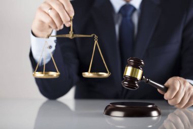Beyaz arka plan üzerinde takım elbiseli adam. Hukuk iş kavramı. Yargıç tokmak ve adalet ölçeği.