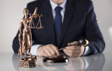 Beyaz arka plan üzerinde takım elbiseli adam. Hukuk iş kavramı. Yargıç tokmak ve adalet heykeli.