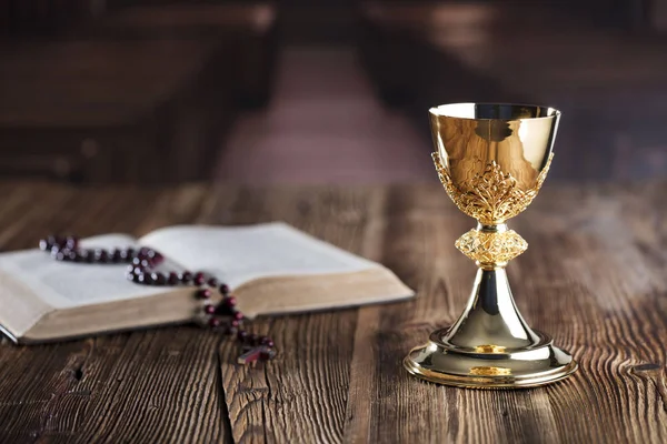 第一个圣餐主题 圣杯和念珠在木桌上 — 图库照片