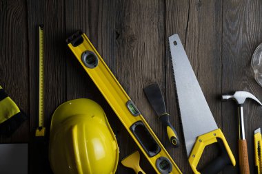 Müteahhit konsepti. Sarı başlık, karalama ve kırsal ahşap arka plandaki diğer araçlar.