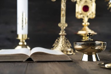 Roma Katolik Kilisesi teması. Haç, Kutsal İncil, Monstrance, rustik ahşap masada tespih ve altın kadeh..