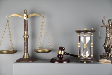 Yargıç ve adalet kavramı. Heykel, ölçek, tokmak ve beyaz arka planda kum saati..