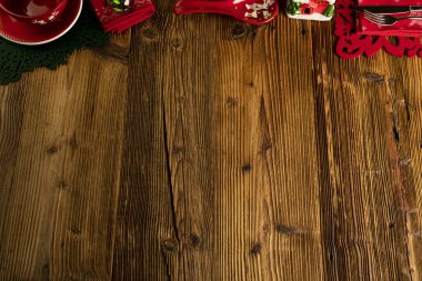 Noel zamanı. Noel sofra takımı ve süslemeleri. Kırmızı ve kahverengi renkler. Kırsal ahşap arkaplan.