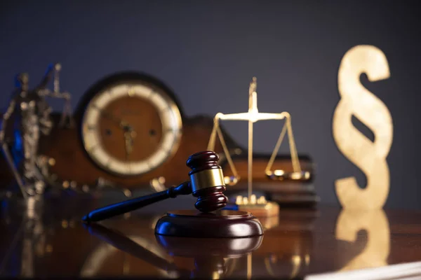 Law concept. Judges gavel, scale and old clock on dark background