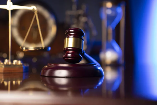 Law concept. Judges gavel, scale and old clock on dark background.