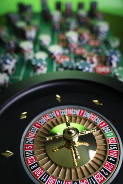 Kumarhane teması, ruleti kapat, kırmızı ve siyah numaralar. Arkaplanda çip yığını.