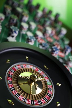 Kumarhane teması, ruleti kapat, kırmızı ve siyah numaralar. Arkaplanda çip yığını.