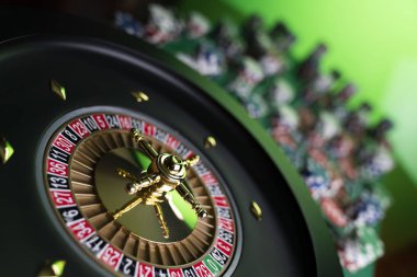 Kumarhane teması, ruleti kapat, kırmızı ve siyah numaralar. Arkaplanda çip yığını.