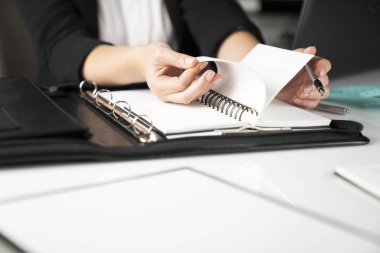 Ofiste çalışan iş kadınının kırpılmış görüntüsü, masaüstündeki malzemeler
