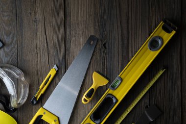 Müteahhit konsepti. Sarı başlık, karalama ve kırsal ahşap arka plandaki diğer araçlar.