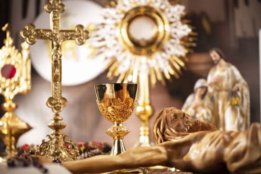 Roma Katolik Kilisesi teması. Haç, Kutsal İncil, Monstrance, rustik ahşap masada tespih ve altın kadeh.