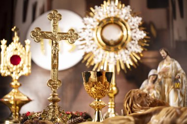 Roma Katolik Kilisesi teması. Haç, Kutsal İncil, Monstrance, rustik ahşap masada tespih ve altın kadeh.