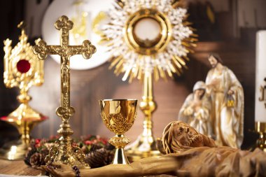 Roma Katolik Kilisesi teması. Haç, Kutsal İncil, Monstrance, rustik ahşap masada tespih ve altın kadeh.