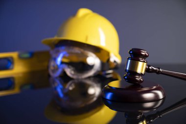 Ahşap yargıç tokmağı ve arka planda inşaat araçları