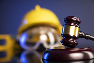 Ahşap yargıç tokmağı ve arka planda inşaat araçları