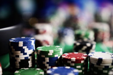 Kumarhane fişleri yeşil keçeli poker masasında.