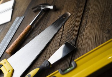 Ahşap masa arkaplanının her tarafında inşaat araçları olan alanı kopyala