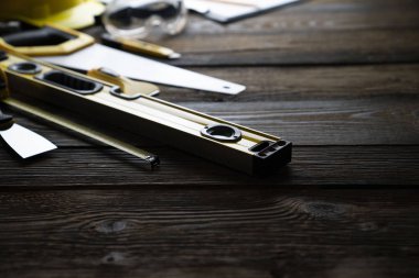 Ahşap masa arkaplanının her tarafında inşaat araçları olan alanı kopyala