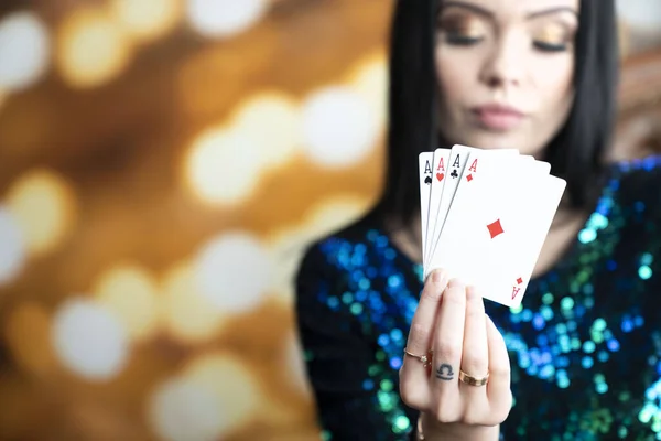 Casino. Portrait of pretty young woman holding playing cadrs in her hand. Young pretty woman holding chips in her hand. Winning combination of poker cards. Female casino player.
