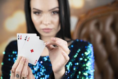 Kumarhane. Elinde kadroları tutan güzel bir genç kadının portresi. Elinde çip tutan genç ve güzel bir kadın. Poker kartlarının galibiyet kombinasyonu. Kadın kumarhane oyuncusu.