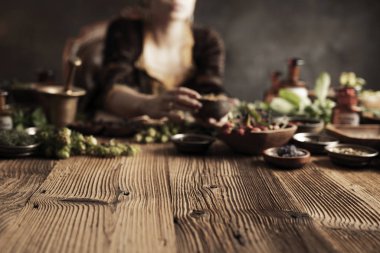 Doğal tıp konsepti. Antika eczacı, doğal ilaç hazırlıyor. Pirinç havan ve şişe. Kırsal masa. Çimli ve sade bitkiler vardır..