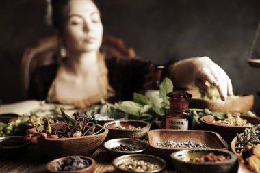 Doğal tıp konsepti. Antika eczacı, doğal ilaç hazırlıyor. Pirinç havan ve şişe. Kırsal masa. Çimli ve sade bitkiler vardır..