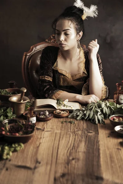 Natural medicine concept. Vintage pharmacist preparing natural medicament. Brass mortar and  bottles. Rustic table. Assorted dry herbs in bowls.