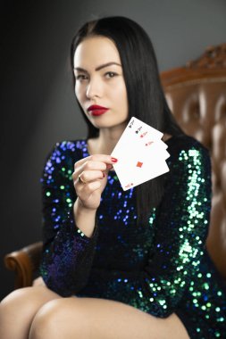 Kumarhane. Elinde kadroları tutan güzel bir genç kadının portresi. Poker kartlarının galibiyet kombinasyonu. Kadın kumarhane oyuncusu.