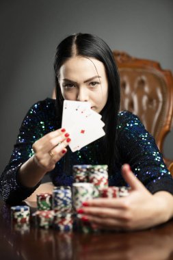 Kumarhane. Elinde kadroları tutan güzel bir genç kadının portresi. Poker kartlarının galibiyet kombinasyonu. Kadın kumarhane oyuncusu.