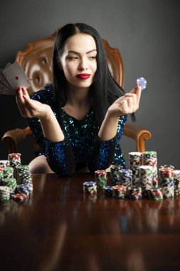 Kumarhane. Elinde kadroları tutan güzel bir genç kadının portresi. Poker kartlarının galibiyet kombinasyonu. Kadın kumarhane oyuncusu.