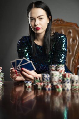 Kumarhane. Elinde kadroları tutan güzel bir genç kadının portresi. Poker kartlarının galibiyet kombinasyonu. Kadın kumarhane oyuncusu.