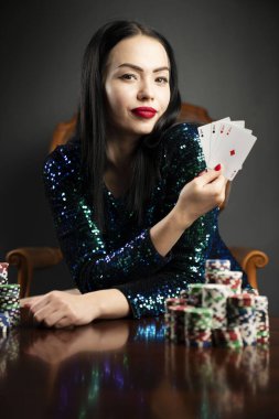 Kumarhane. Elinde kadroları tutan güzel bir genç kadının portresi. Poker kartlarının galibiyet kombinasyonu. Kadın kumarhane oyuncusu.