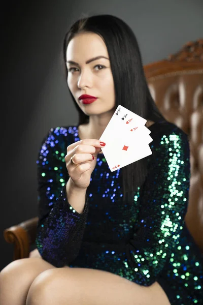 Casino. Portrait of pretty young woman holding playing cadrs in her hand.  Winning combination of poker cards. Female casino player.