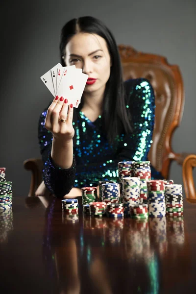 Kumarhane. Elinde kadroları tutan güzel bir genç kadının portresi. Poker kartlarının galibiyet kombinasyonu. Kadın kumarhane oyuncusu.