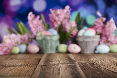 Paskalya geçmişi. Laleler ve bahar çiçekleri. Paskalya yumurtaları. Kırsal ahşap masa. Pastel renkler bokeh. Tipografi için yer.