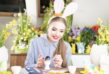 Tavşan kulaklı, Paskalya yumurtası boyayan hoş genç kadınlar. Paskalya geçmişi. Bahar çiçekleri. Sepetlerdeki Paskalya yumurtaları.
