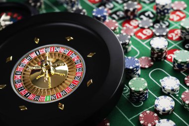 Kumarhanede rulet masası. Kumarhane, üzerinde kırmızı ve siyah sayılar olan yeşil bir masa hissetti. Poker fişleri yığını.