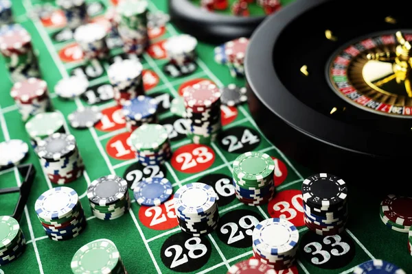 Roulette table in casino. Casino felt green table with red and black numbers. Stack of poker chips.