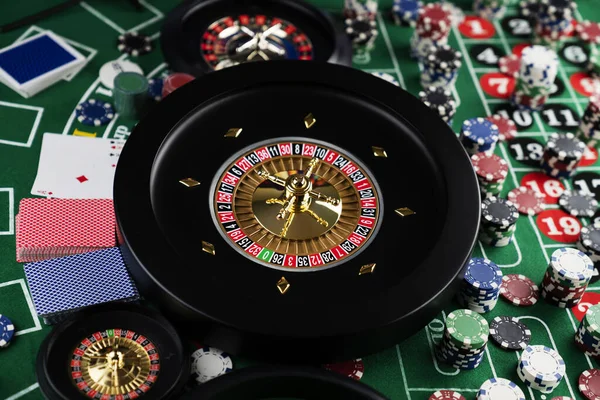 Roulette table in casino. Casino felt green table with red and black numbers. Stack of poker chips.