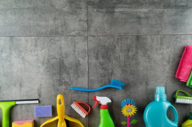 Bahar evi temizliği. Gri fayanslarda renkli temizlik seti. Üst görünüm.