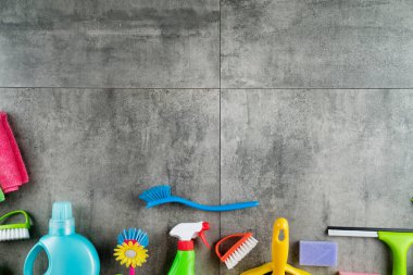 Bahar evi temizliği. Gri fayanslarda renkli temizlik seti. Üst görünüm.